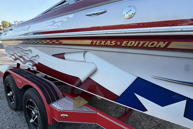 Slide: The Image of 2006 Profile 260 V Texas Edition boat with custom graphics on a red trailer. - 28