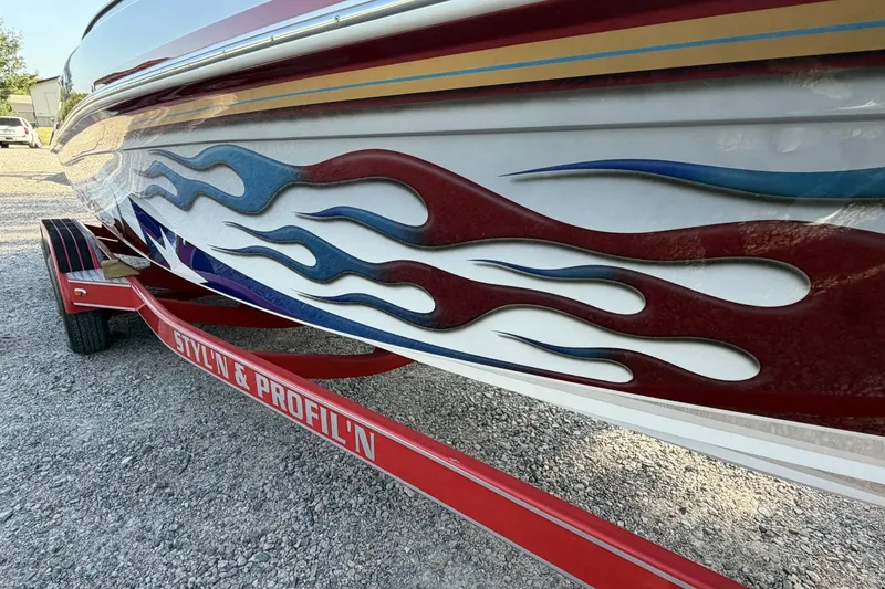 Slide: The Image of 2006 Profile 260 V boat with flame graphics on a red trailer. - 26