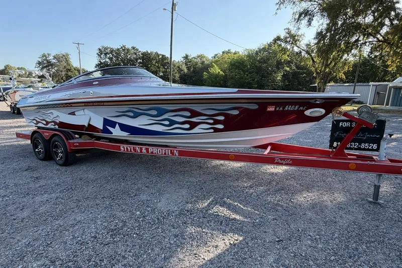 Slide: The Image of 2006 Profile 260 V boat with custom Texas-themed design on a red trailer. - 25
