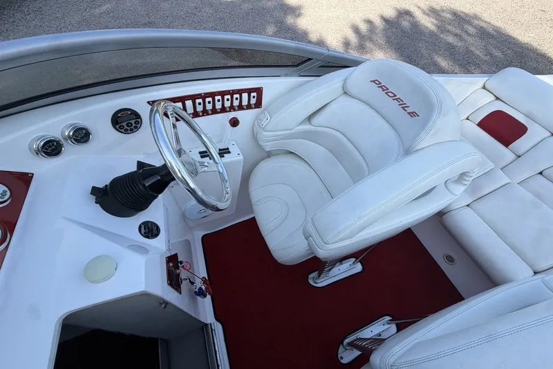 Slide: The Image of Interior of a 2006 Profile 260 V boat with white seating and red accents. - 21
