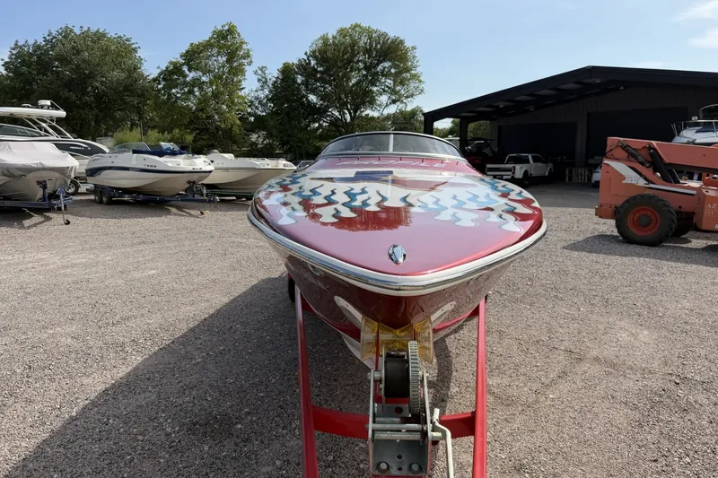 Slide: The Image of 2006 Profile 260 V boat with vibrant paint, parked outdoors among other boats. - 7