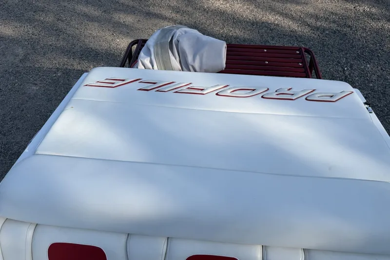 Slide: The Image of Rear view of a 2006 Profile 260 V boat with white upholstery and red accents. - 14