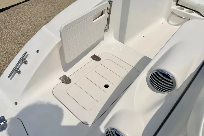 Slide: The Image of 2008 Starcraft 2000 IO Limited boat interior with storage compartment and cup holders. - 25