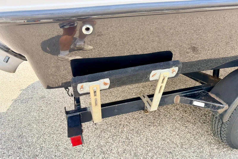 Slide: The Image of 2008 Starcraft 2000 IO Limited boat trailer with black hull and support brackets. - 78