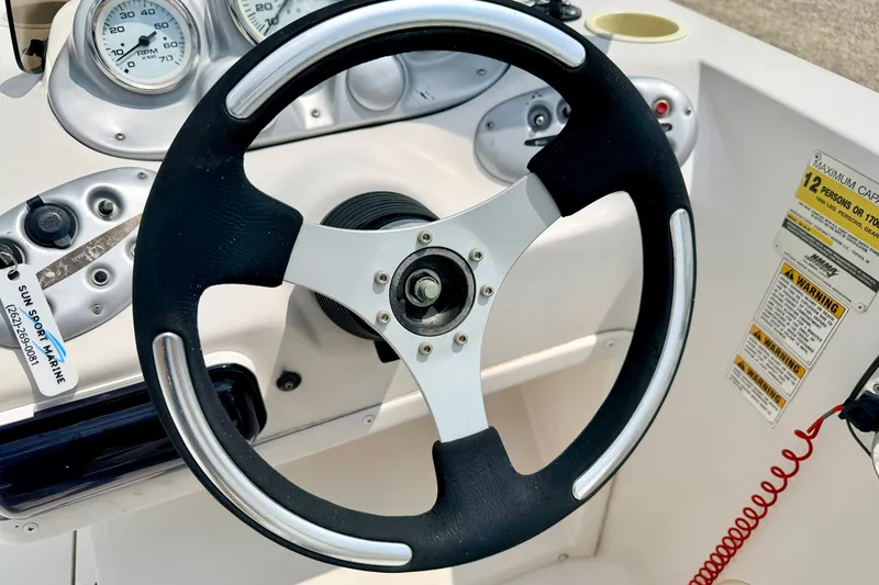 Slide: The Image of Steering wheel of a 2008 Starcraft 2000 IO Limited boat with dashboard gauges. - 39