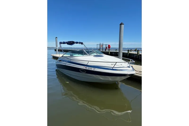 Slide: The Image of 2012 Crownline 236 SC boat docked on calm water under clear blue sky. - 54