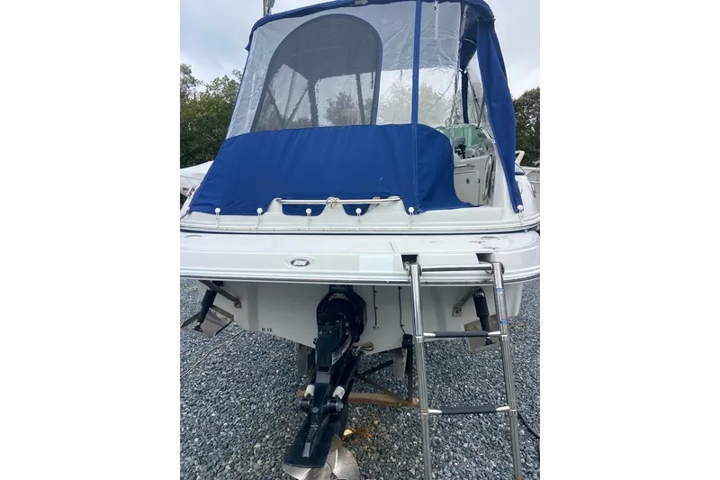 Slide: The Image of 2012 Crownline 236 SC boat with blue canopy and ladder, rear view. - 13