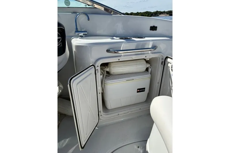 Slide: The Image of 2012 Crownline 236 SC boat interior with open storage compartment and cooler. - 42