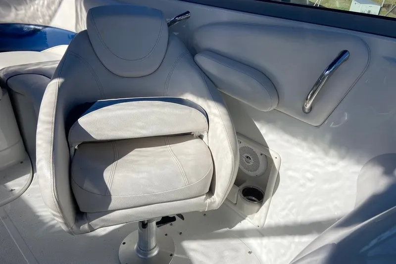 Slide: The Image of Captain's seat in a 2012 Crownline 236 SC boat, featuring white upholstery and sleek design. - 24