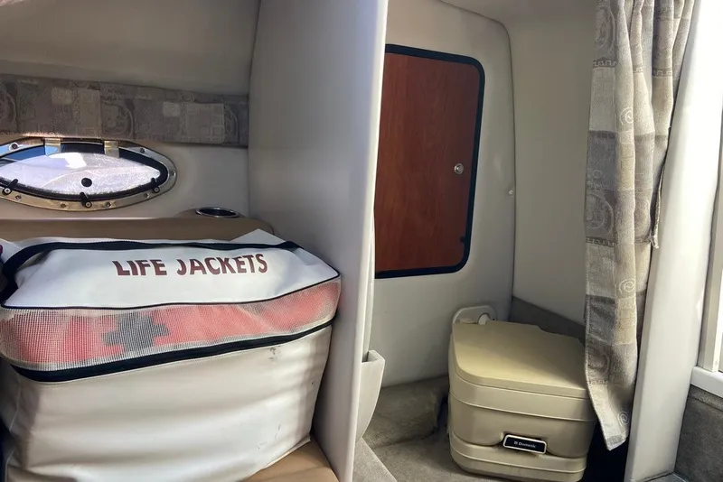 Slide: The Image of Interior of 2012 Crownline 236 SC boat with life jackets and portable toilet. - 21