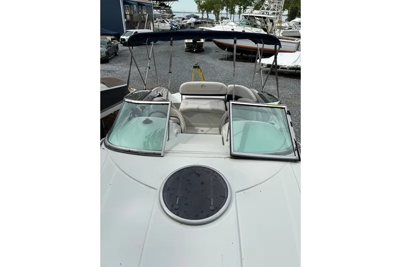 Slide: The Image of 2012 Crownline 236 SC boat with open windshield and canopy in a marina. - 34