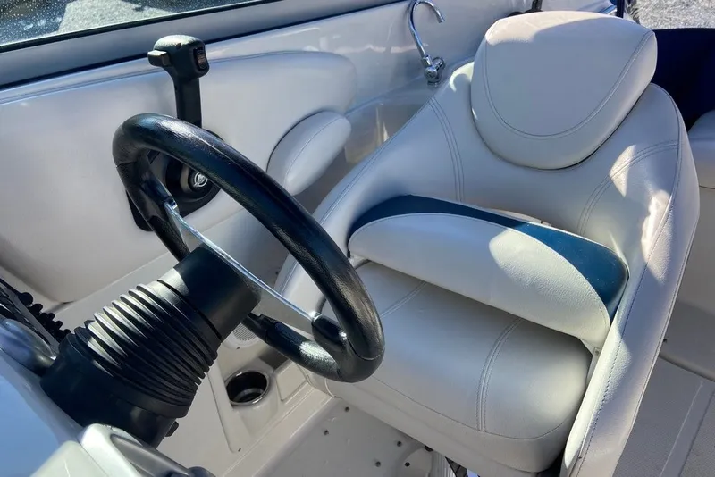 Slide: The Image of Interior of 2012 Crownline 236 SC boat with steering wheel and white captain's chair. - 25
