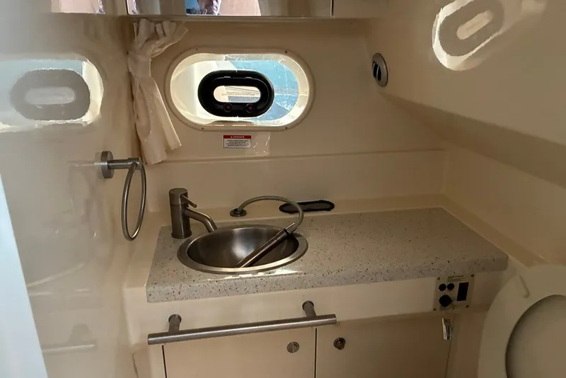 Slide: The Image of 2012 Crownline 236 SC boat interior with sink, countertop, and porthole window. - 32