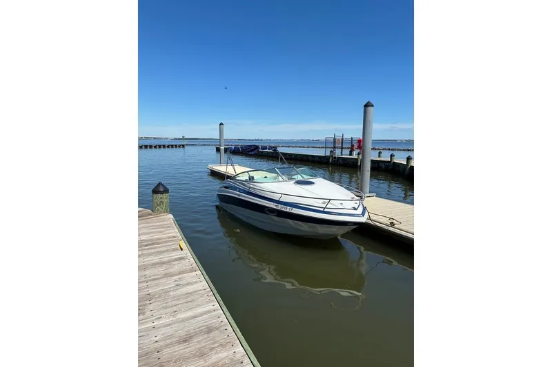Slide: The Image of 2012 Crownline 236 SC boat docked at a marina under clear blue skies. - 53
