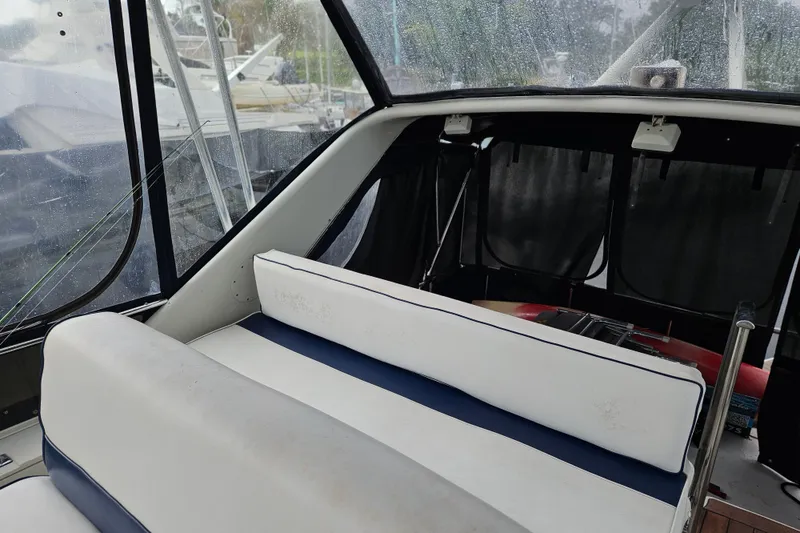 Slide: The Image of 1988 Wellcraft San Remo boat interior with white seating and rain-speckled windows. - 15