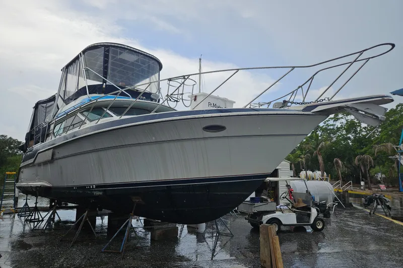 Slide: The Image of 1988 Wellcraft San Remo yacht on stands, marina background, overcast sky. - 34