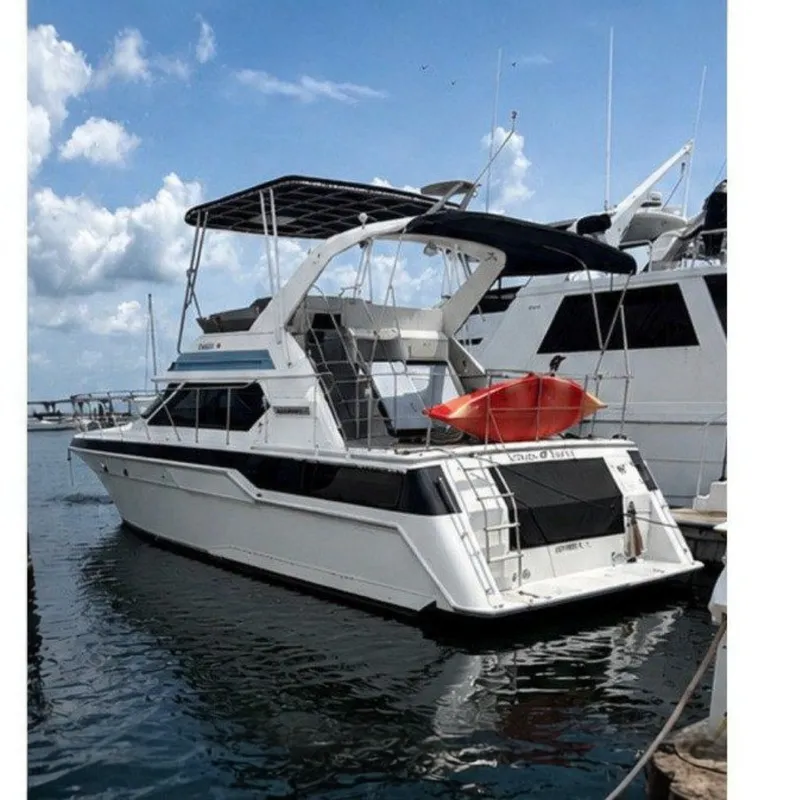 The Image of 1988 Wellcraft San Remo yacht docked at marina under blue sky. - 0