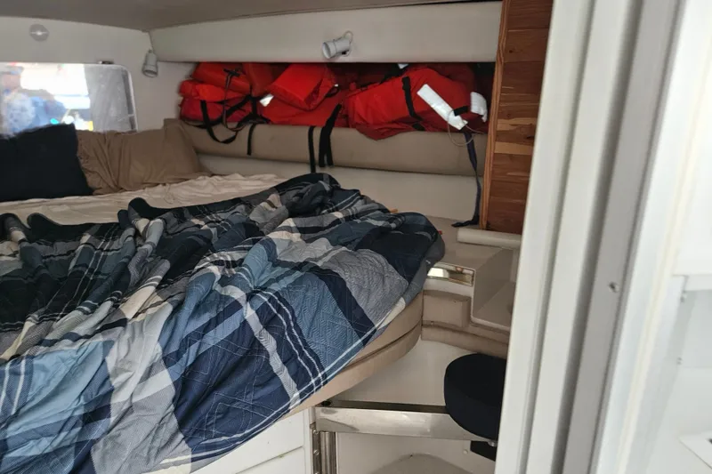 Slide: The Image of Interior of 1988 Wellcraft San Remo boat with bed, life jackets, and plaid bedding. - 23