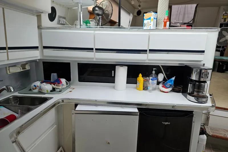 Slide: The Image of 1988 Wellcraft San Remo yacht kitchen with sink, cabinets, coffee maker, and countertop essentials. - 25