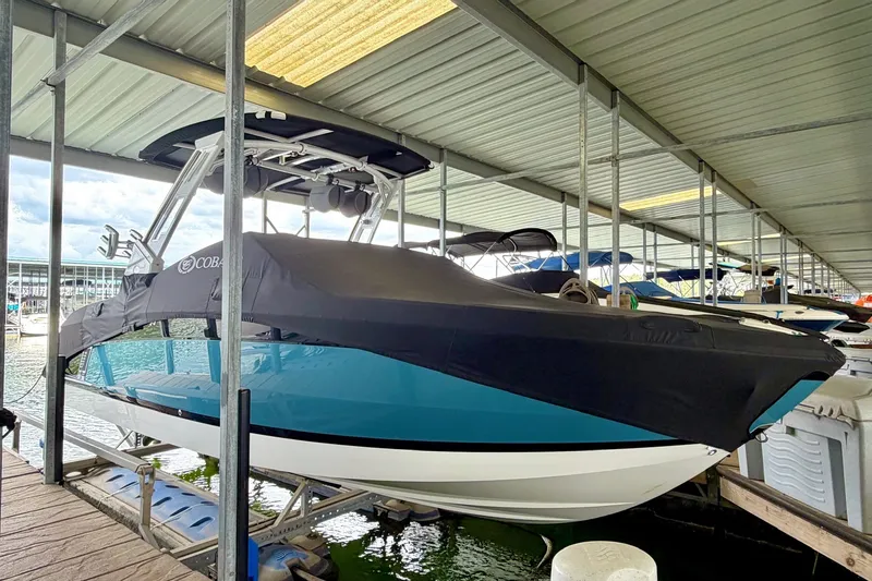 Slide: The Image of 2023 Cobalt R6 Surf boat docked under a covered marina, partially covered. - 29