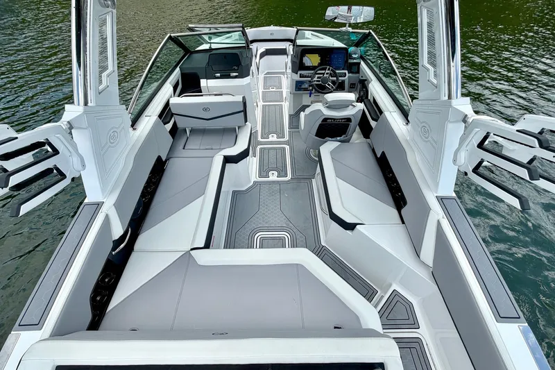 Slide: The Image of 2023 Cobalt R6 Surf boat interior with sleek seating and modern dashboard on water. - 14