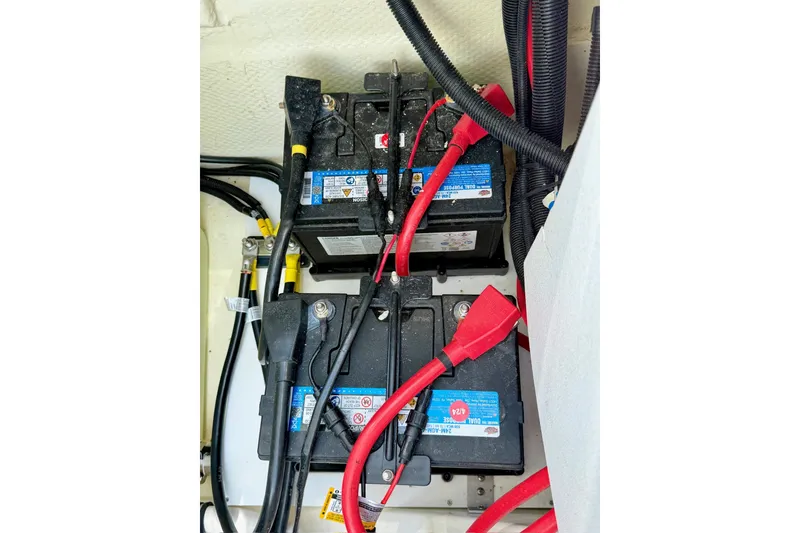Slide: The Image of 2023 Cobalt R6 Surf boat battery compartment with connected cables. - 24