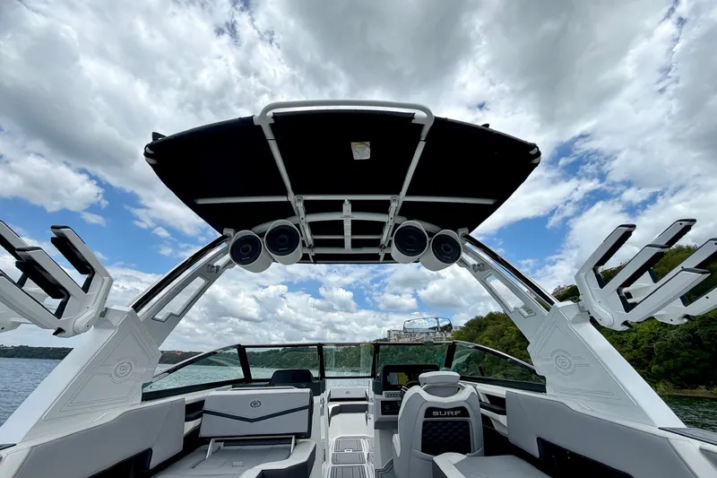 Slide: The Image of 2023 Cobalt R6 Surf boat interior with speakers, under a cloudy sky. - 12