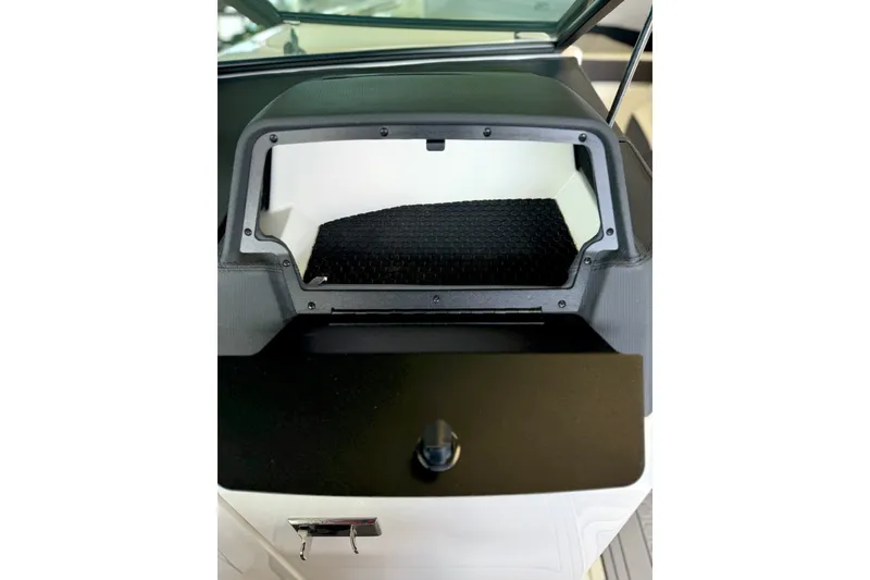 Slide: The Image of 2023 Cobalt R6 Surf boat dashboard storage compartment with black trim and latch. - 34