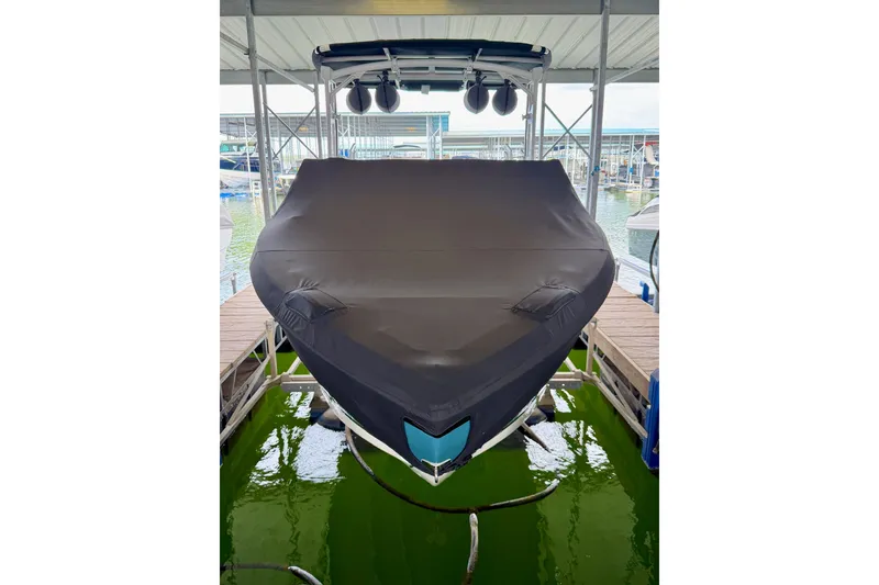 Slide: The Image of 2023 Cobalt R6 Surf boat covered in dock, front view. - 28