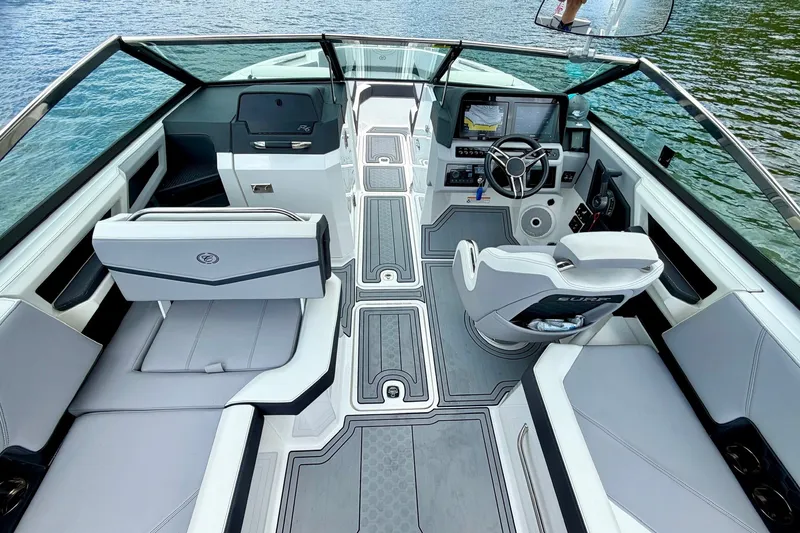 Slide: The Image of 2023 Cobalt R6 Surf boat interior with modern dashboard and seating on a lake. - 15