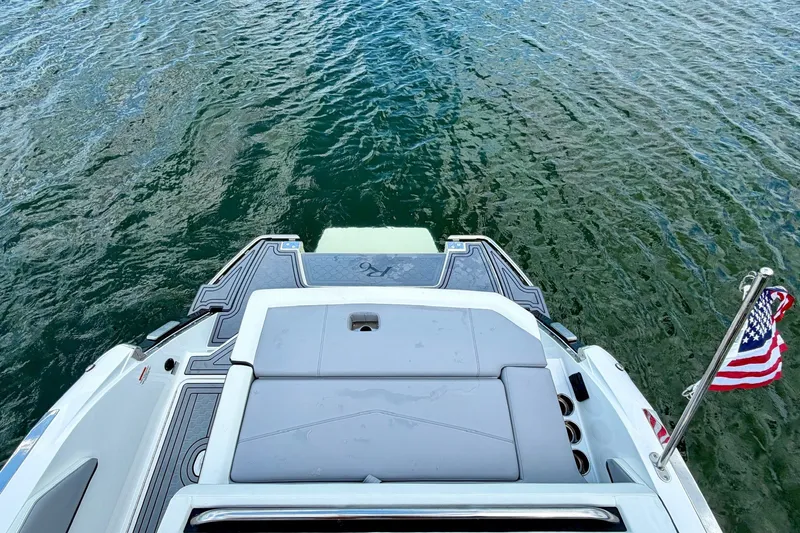 Slide: The Image of 2023 Cobalt R6 Surf boat stern with American flag on water. - 11