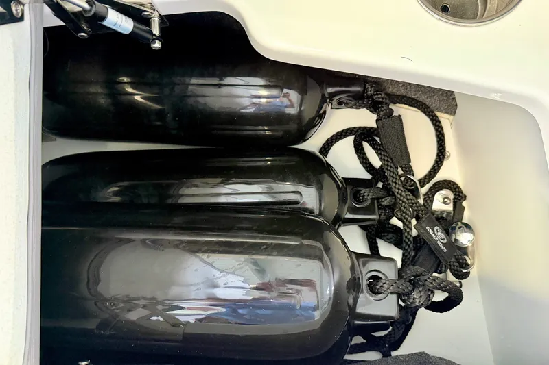 Slide: The Image of Storage compartment with black fenders on a 2023 Cobalt R6 Surf boat. - 36