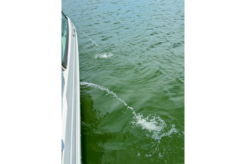 Slide: The Image of 2023 Cobalt R6 Surf boat cruising on green water surface. - 10