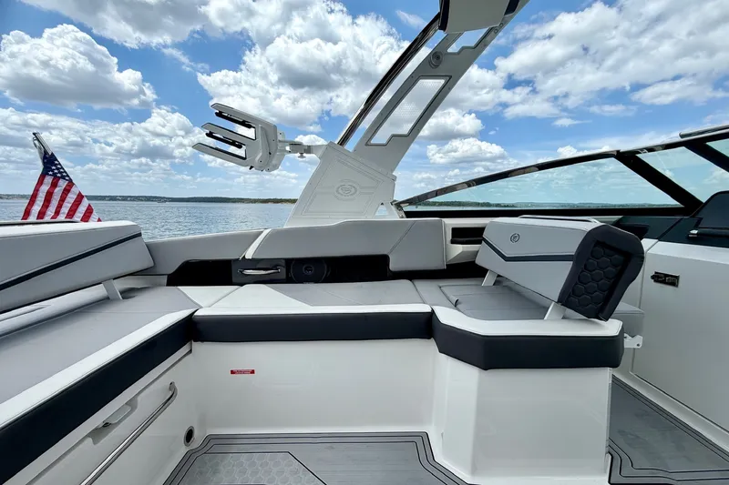Slide: The Image of 2023 Cobalt R6 Surf boat interior with seating, American flag, and lake view. - 17