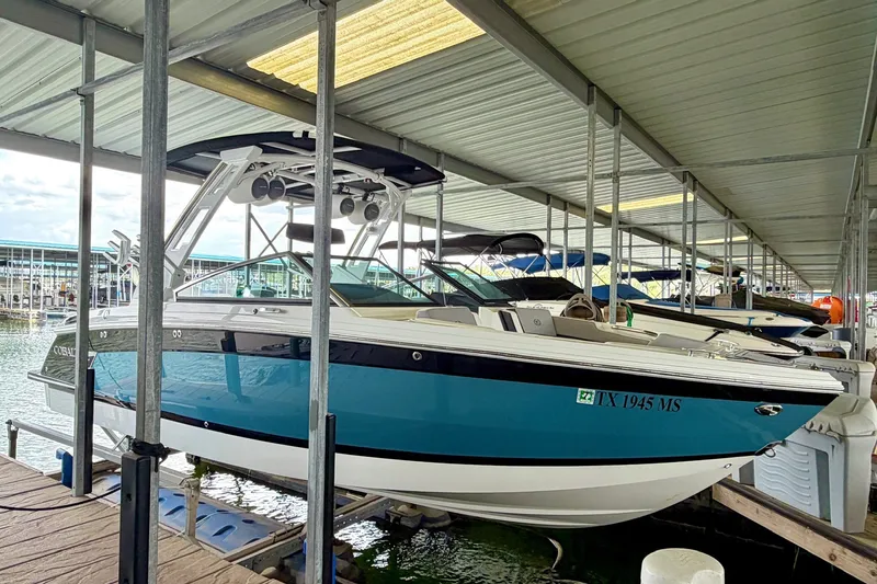 Slide: The Image of 2023 Cobalt R6 Surf boat docked in a marina under a covered shelter. - 26