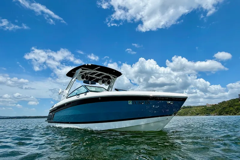 Slide: The Image of 2023 Cobalt R6 Surf boat on water under blue sky with clouds. - 5