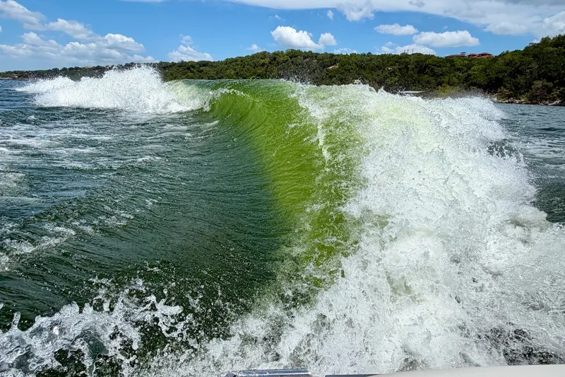 Slide: The Image of Waves created by 2023 Cobalt R6 Surf boat on a sunny day. - 9