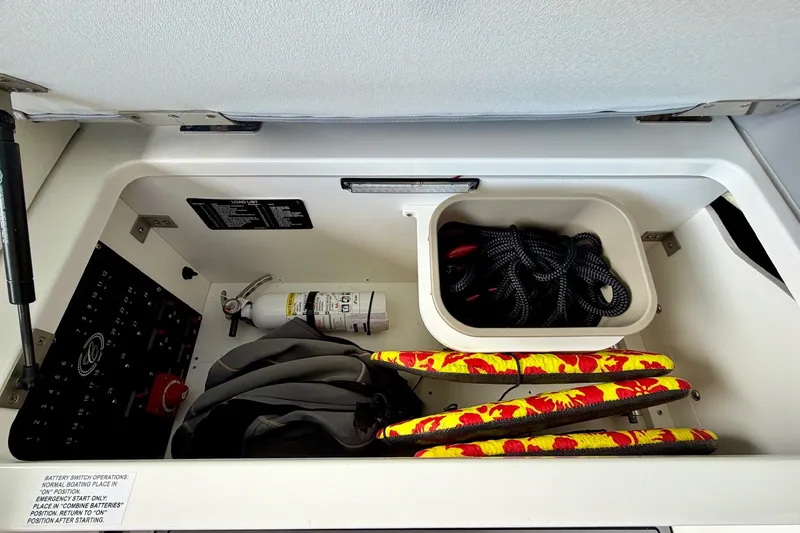 Slide: The Image of Storage compartment of 2023 Cobalt R6 Surf boat with safety equipment and ropes. - 39