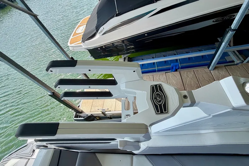 Slide: The Image of 2023 Cobalt R6 Surf boat with sleek design and modern features docked by the water. - 47