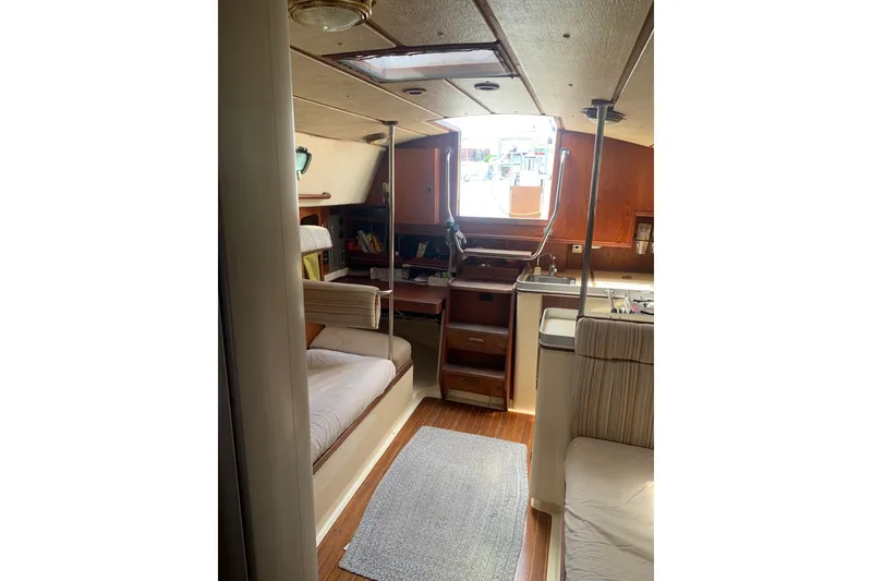 Slide: The Image of Interior of a 1984 CS Sailcraft yacht, featuring cozy seating and wooden cabinetry. - 4