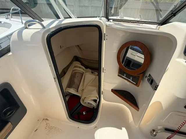 Slide: The Image of The image shows the interior of a 2015 Grady-White Freedom 255 boat with storage and a mirror. - 8