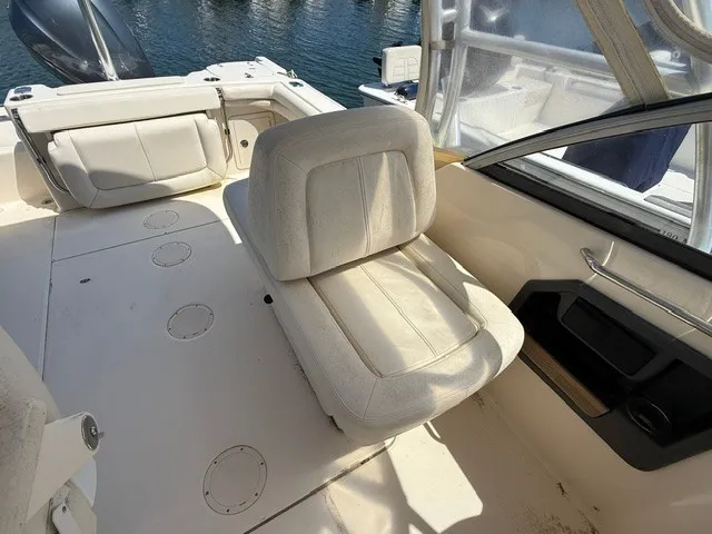Slide: The Image of The image shows the interior of a 2015 Grady-White Freedom 255 boat with white seating. - 10