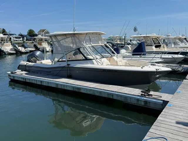 Slide: The Image of A 2015 Grady-White Freedom 255 boat docked in a sunny marina. - 2