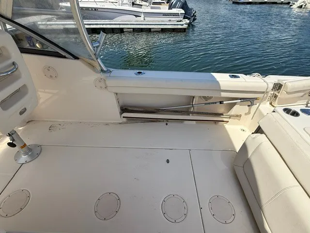 Slide: The Image of The image shows the cockpit of a 2015 Grady-White Freedom 255 boat. It features light upholstery and is docked by the water. - 13