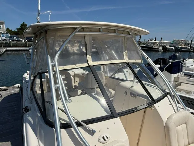 Slide: The Image of A 2015 Grady-White Freedom 255 boat docked. It features a hardtop and clear windows. - 4
