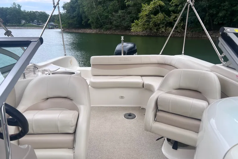 Slide: The Image of 2007 NauticStar 230 Sport Deck boat interior with plush seating, on a serene lake. - 7