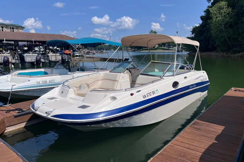The Image of 2007 NauticStar 230 Sport Deck boat docked at marina under clear blue sky. - 0
