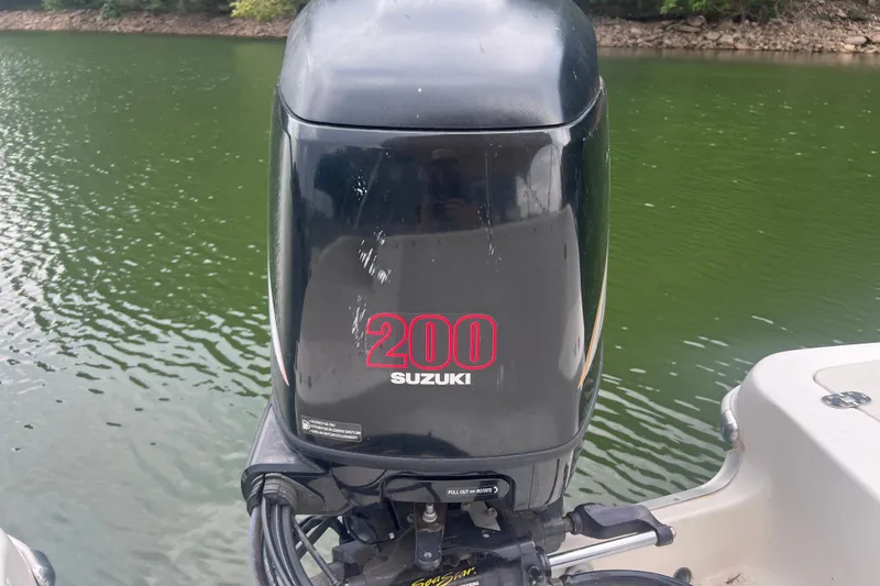 Slide: The Image of Suzuki 200 outboard motor on 2007 NauticStar 230 Sport Deck, near green water. - 11