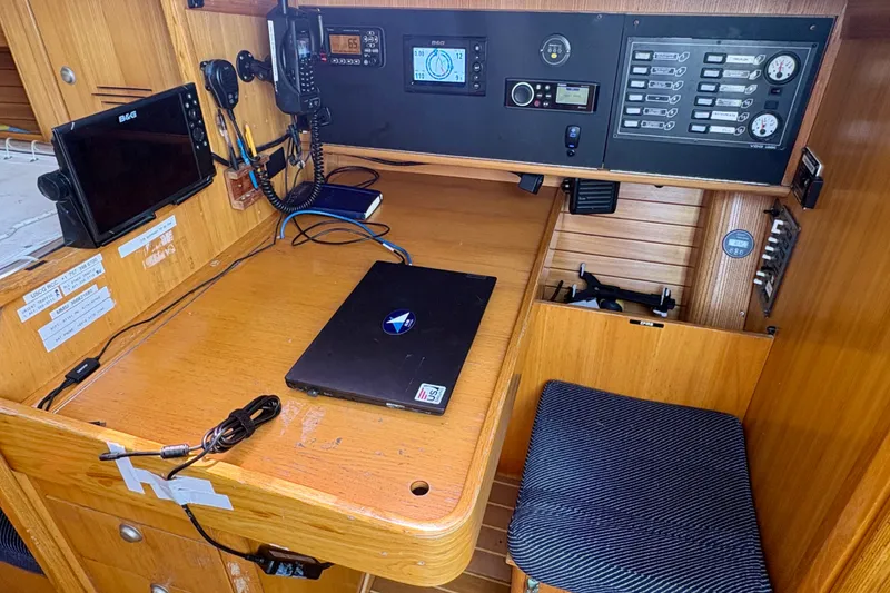 Slide: The Image of Navigation station inside a 2000 J Boats J/120 sailboat, featuring electronics and a laptop. - 12