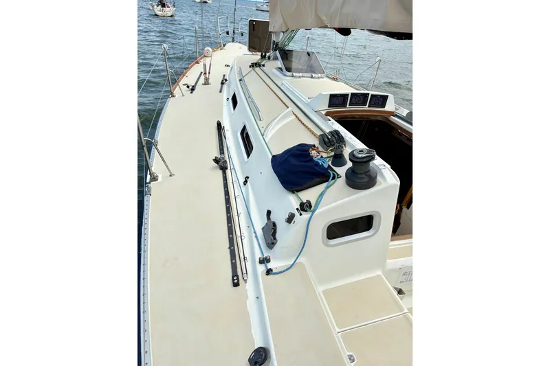 Slide: The Image of 2000 J Boats J/120 sailboat deck with winches and ropes, docked on calm water. - 6